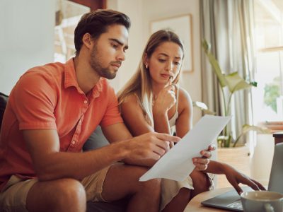 Anxiety, debt and stress with a couple paying bills on a laptop, checking their budget and savings.